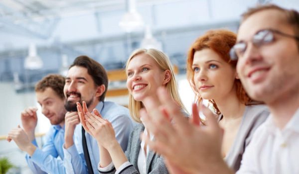 Image of a business team with its leader being at the conference on the foreground